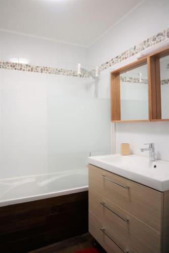 une salle de bain avec un lavabo et une baignoire dans l'établissement TRENTEMOULT-REZE : 2 chambres, 65m²+parking+wifi, à Rezé