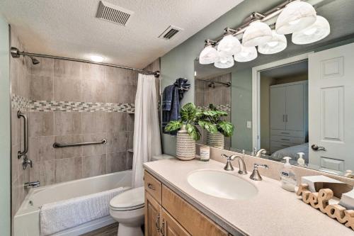 a bathroom with a sink and a toilet and a mirror at Waterfront Nokomis Condo Less Than Half Mile to Beach! in Nokomis