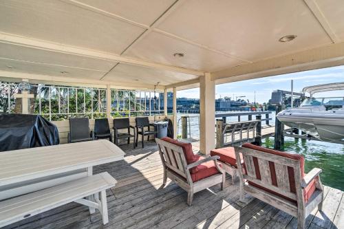 a boat deck with chairs and a table and a boat at Waterfront Nokomis Condo Less Than Half Mile to Beach! in Nokomis