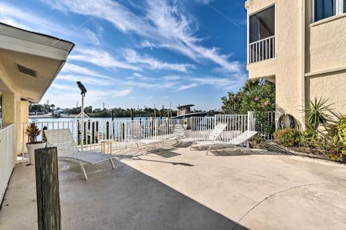 a group of chairs sitting on a patio near the water at Waterfront Nokomis Condo Less Than Half Mile to Beach! in Nokomis