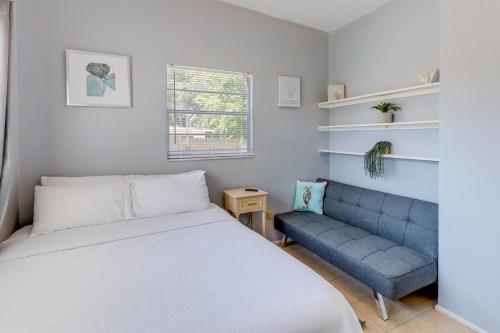 sypialnia z łóżkiem i niebieską kanapą w obiekcie Titusville Vacation Rental with Private Pool! w mieście Titusville