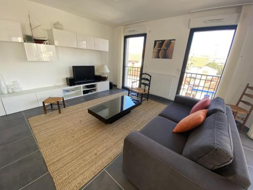 un salon avec un canapé et une télévision dans l'établissement Bel appartement en centre-ville d'Arcachon, résidence récente, proche plages, pour 4 personnes - FR-1-474-185, à Arcachon