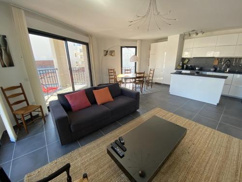 un salon avec un canapé et une cuisine dans l'établissement Bel appartement en centre-ville d'Arcachon, résidence récente, proche plages, pour 4 personnes - FR-1-474-185, à Arcachon