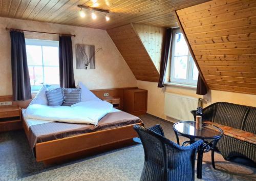 a bedroom with a bed and a table and windows at Hotel Klett B&B in Langenargen