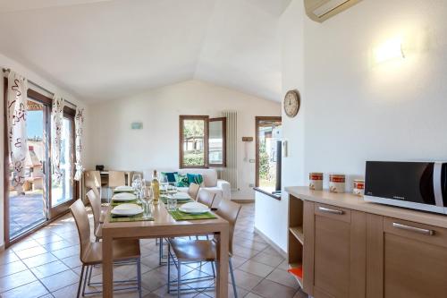 una cucina e una sala da pranzo con tavolo e sedie di The Veranda Holiday a Badesi