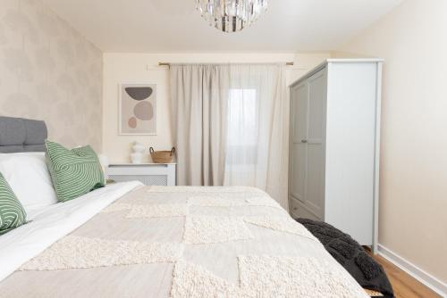 a bedroom with a white bed and a chandelier at Luxury Apartment, Birmingham-Parking in Birmingham