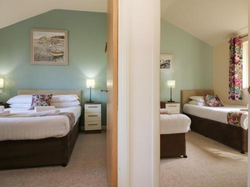 um quarto com 2 camas e um espelho em Chalet Log Cabin L2 em Ilfracombe