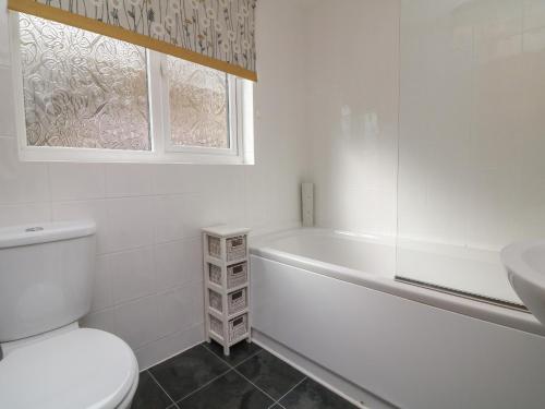 uma casa de banho com um WC, uma banheira e um lavatório. em Chalet Log Cabin L2 em Ilfracombe