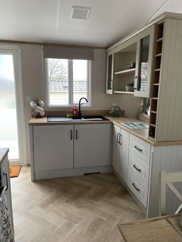 eine Küche mit weißen Schränken und einem Waschbecken in der Unterkunft The avenue, Waterside in Paignton