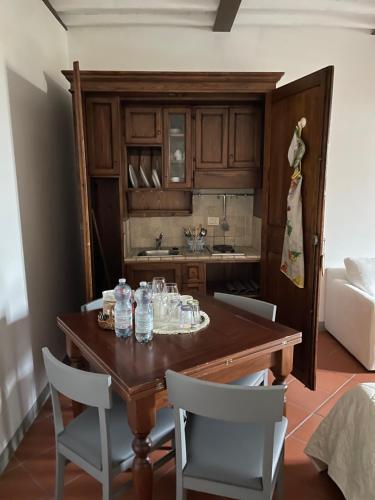 a kitchen with a wooden table and white chairs at La Fattoria di Rendola in Montevarchi