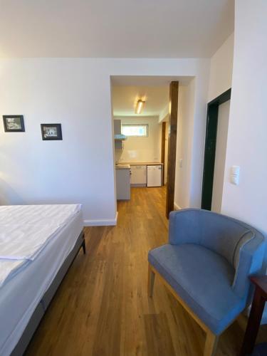 a bedroom with a bed and a blue chair at Hotel Elefant in Schwerin