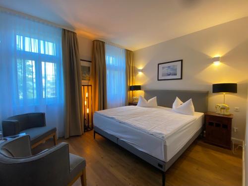 a bedroom with a bed and a chair and window at Hotel Elefant in Schwerin