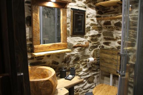 a bathroom with a wooden sink and a stone wall at il Bosco in Roccaforte Mondovì