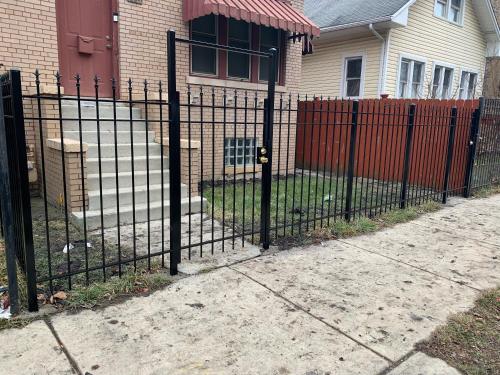 a black fence in front of a house at A Hidden Gem, approx 15 mins to downtown Chicago! in Chicago