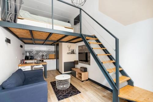 un appartement loft avec un canapé bleu et un lit superposé dans l'établissement Charmant hypercentre tram design, à Saint-Étienne