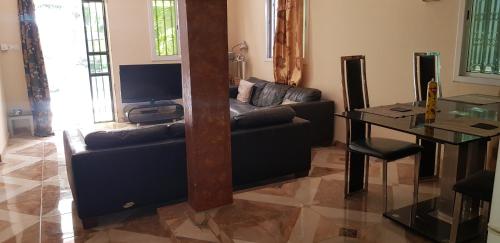 a living room with a couch and a table at The bb's in Brusubi