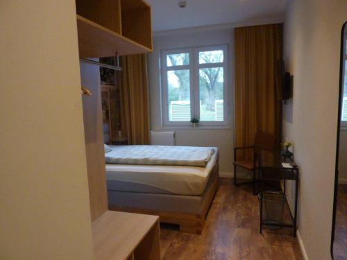 a small bedroom with a bed and a window at Niemann's Gasthof in Reinbek