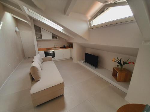 un salon avec un canapé blanc et une télévision dans l'établissement GT Apartments - New opening, à Vibo Valentia Marina