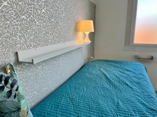 a bedroom with a bed with a blue comforter at Residence Frontemare in Rimini