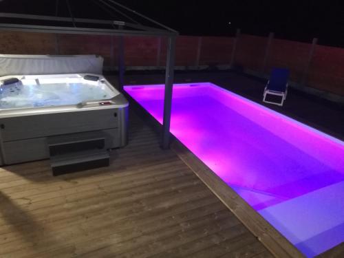 una vasca idromassaggio in una stanza con illuminazione rosa di Magnifique Villa sur le Bassin d'Arcachon - JACUZZI+PISCINE - 8à10pers a Biganos