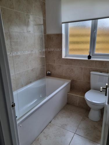 a bathroom with a bath tub and a toilet at Seaview in Trevilley