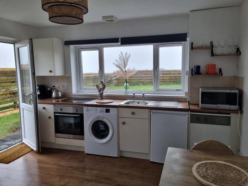 a kitchen with a sink and a washing machine at Seaview in Trevilley