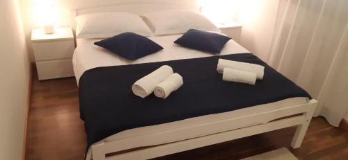 a bed with two pillows and towels on it at Villa Sole in Omišalj