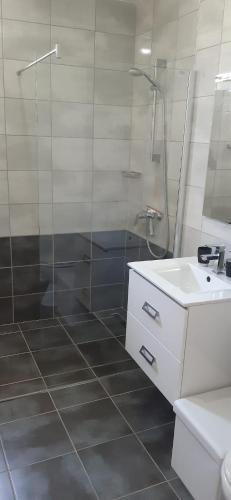 a white bathroom with a shower and a sink at Villa Sole in Omišalj