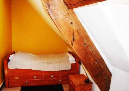 Schlafzimmer mit einem Bett und einer Holzkommode in der Unterkunft Appartement la Roche Bernard in La Roche-Bernard