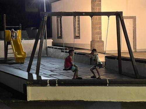 two children playing on a swing set in a playground at Casa da Bicuda in Ribeiras