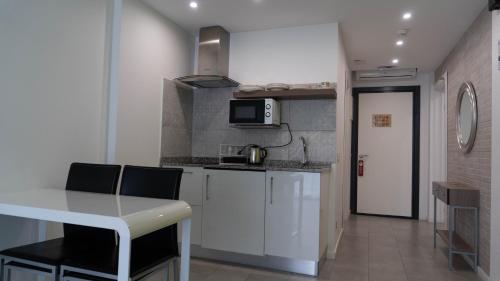 une petite cuisine avec une table et un four micro-ondes dans l'établissement Sofía, à Benidorm