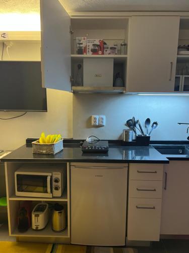 a kitchen with a counter top with a microwave at Casa da Bicuda in Ribeiras
