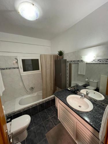 La salle de bains est pourvue d'un lavabo, d'une baignoire et de toilettes. dans l'établissement Villa Amarena, à Mitikas
