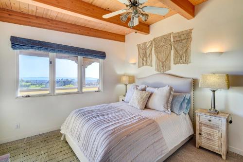 a bedroom with a bed with a ceiling fan and two windows at Luxury Vacation Rental in Oakland, California! in Oakland