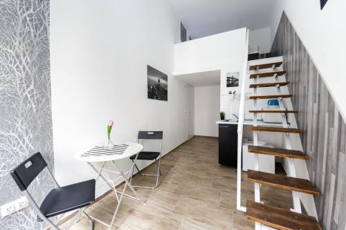 Habitación con mesa, escalera, mesa y sillas. en Rio's Stylish Central Flats, en Budapest