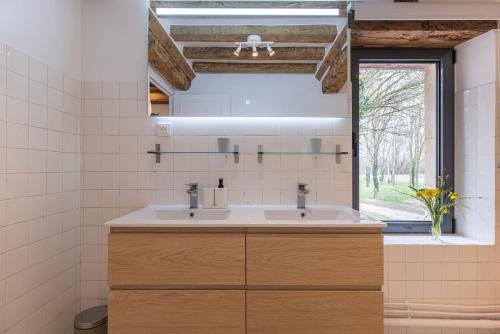 a bathroom with a sink and a mirror at La Maison Cornière in Biéville-en-Auge