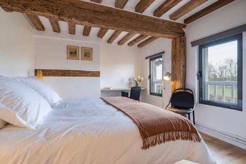 Un dormitorio con una cama grande y una ventana en La Maison Cornière, en Biéville-en-Auge