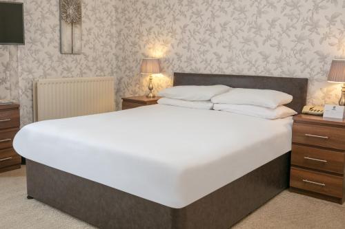 a large white bed in a bedroom with wallpaper at Lord Haldon Country Hotel, Sure Hotel Collection by Best Western in Exeter