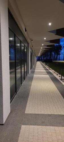 an empty hallway of a building with windows at PINEA Apartments Pobierowo z niesamowitym widokiem na morze oraz jacuzzi w wybranych apartamentach in Pobierowo
