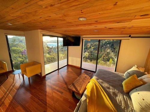 Schlafzimmer mit großen Fenstern und einem Bett in einem Zimmer in der Unterkunft Hermosa casa privada con jacuzzi y una vista espectacular al lago in Valle de Bravo