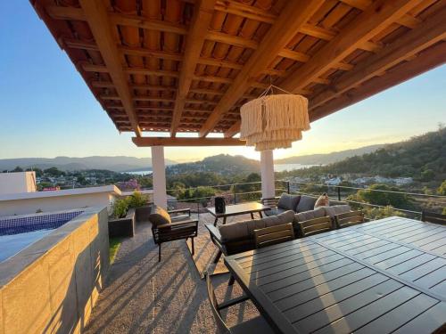 a patio with a table and chairs on a roof at Hermosa casa privada con jacuzzi y una vista espectacular al lago in Valle de Bravo