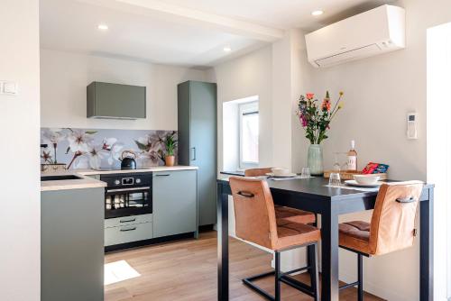 a kitchen with a black table and two chairs at Sunnyzandvoort in Zandvoort