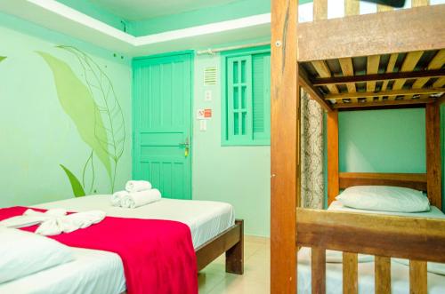a bedroom with two beds and a bunk bed at Verde Hostel Ilhabela in Ilhabela