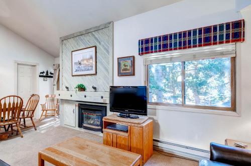 a living room with a television and a fireplace at The Forest Neighborhood by Keystone Resort in Keystone