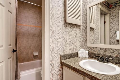 a bathroom with a sink and a mirror and a shower at The Forest Neighborhood by Keystone Resort in Keystone