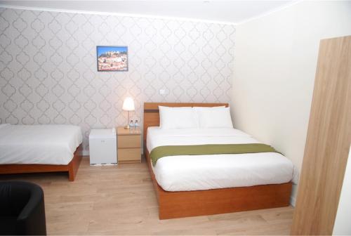 a small room with two beds and a table at Amor Lisboa Hostel in Lisbon