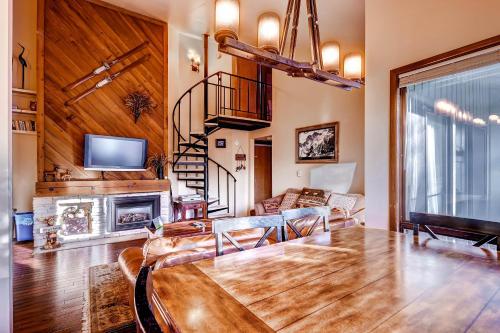 a living room with a wooden table and a fireplace at The Forest Neighborhood by Keystone Resort in Keystone