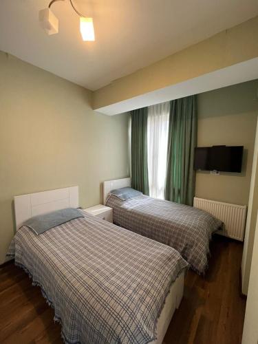 2 łóżka w małym pokoju z oknem w obiekcie Villa Deluxe Premium Apartment 308 w mieście Bakuriani