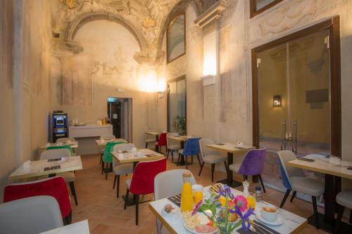 a restaurant with tables and chairs in a room at Casual Rinascimento Firenze in Florence