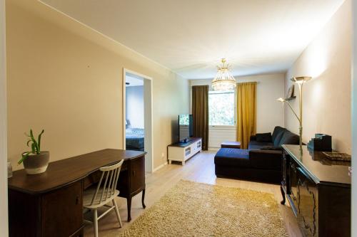 a living room with a desk and a couch at -Hannula- Hiljainen ja tilava kaksio kahdella autopaikalla kauppojen vieressä in Kuopio